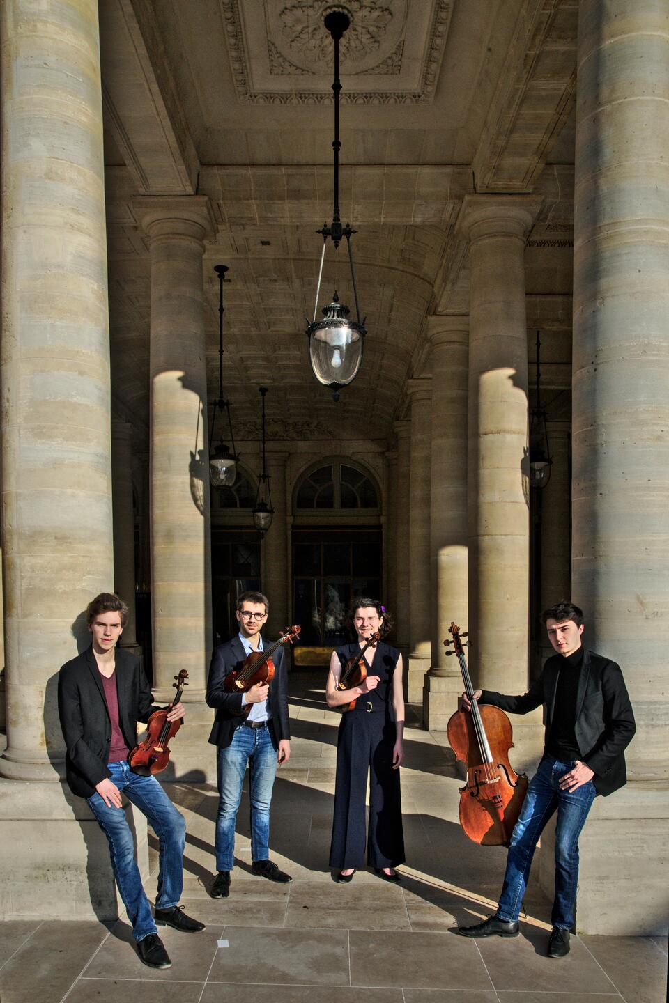 Le quatuor est campé entre les colonnes majestueuses du Palais Royal